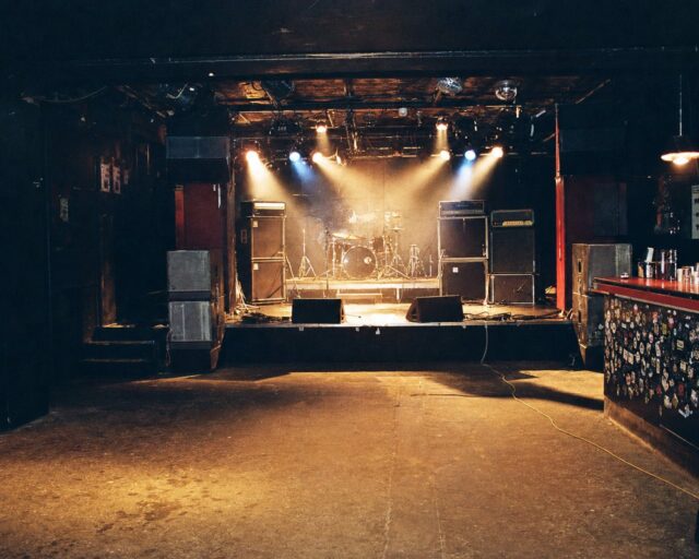 Interior de una sala de conciertos española vacía antes de un concierto, con el escenario y los amplificadores preparados